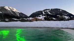 Piscine lumineuse avec vue sur les montagnes enneigées